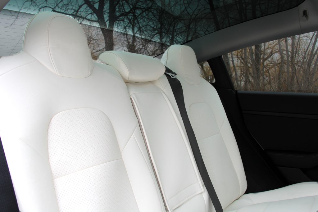 Interior of a Tesla Model 3 with the rear head support visible.