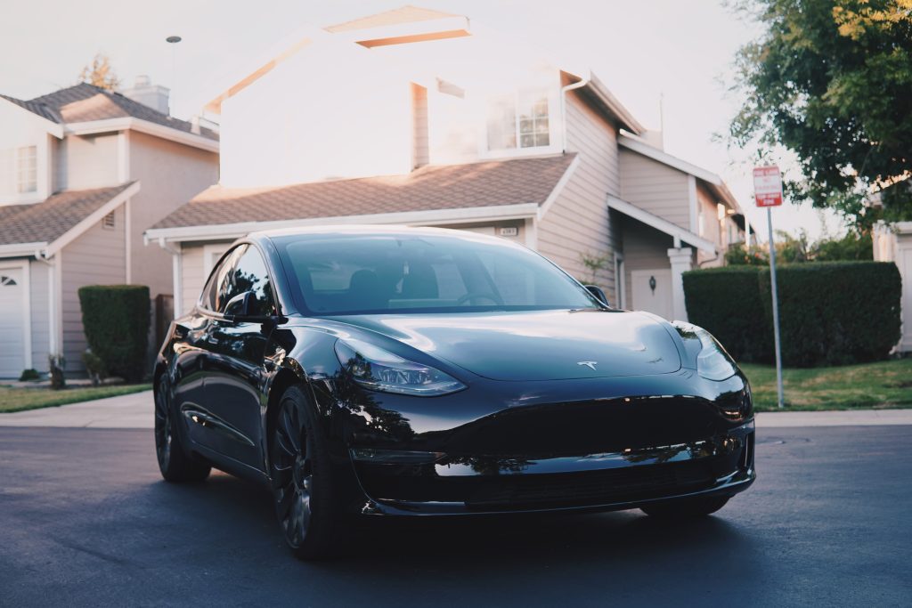 Solid black Tesla Model 3 in a residential neighbourhood