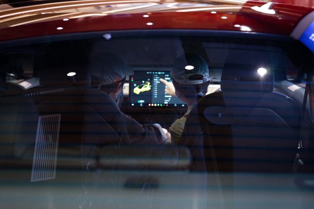 Two People in a Tesla Using the Touchscreen