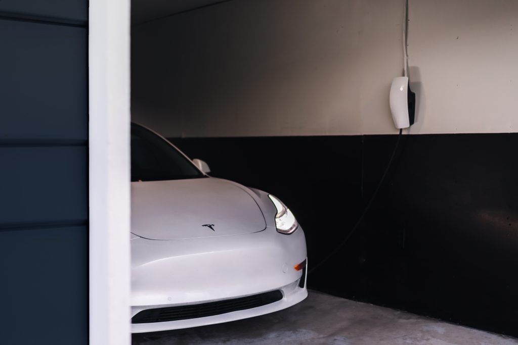 Pearl White Tesla Model 3 Next to a Tesla Wall Connector