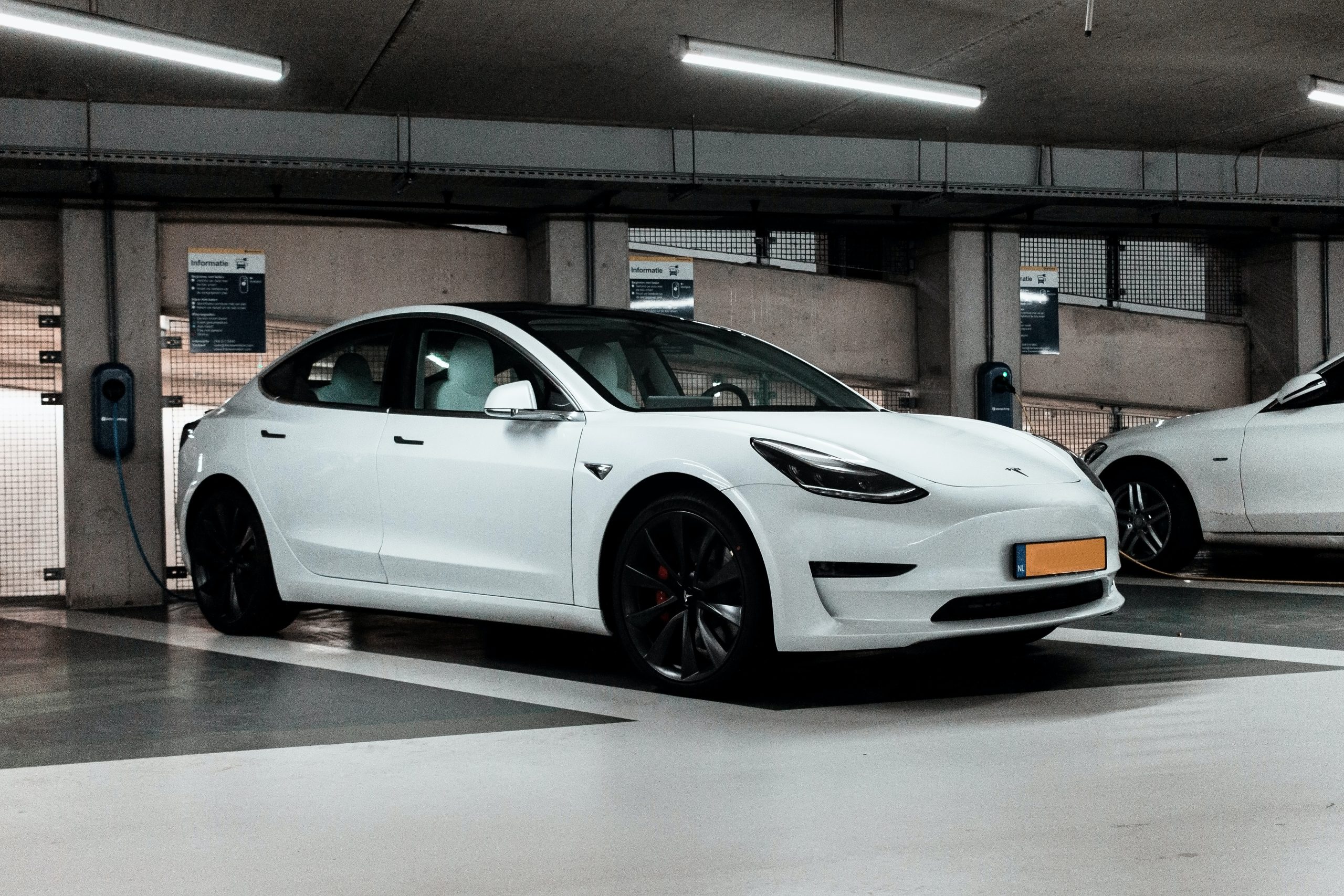 Pearl White Tesla Model 3 Parked in a Parking Garage