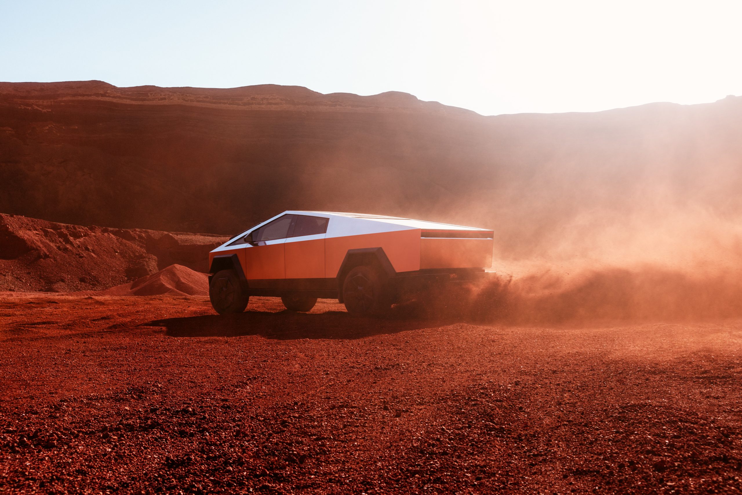 Tesla Cybertruck Driving in a Red Desert Setting